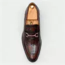 A pair of premium brown leather loafers with an antique gold horsebit and supportive medicated sole.