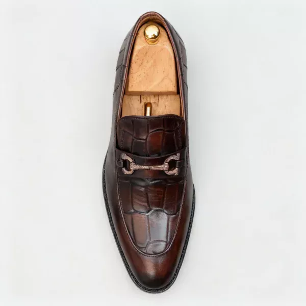 A pair of premium brown leather loafers with an antique gold horsebit and supportive medicated sole.