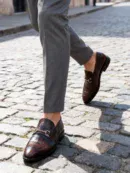 A pair of premium brown leather loafers with an antique gold horsebit and supportive medicated sole.