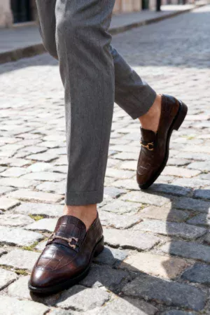 A pair of premium brown leather loafers with an antique gold horsebit and supportive medicated sole.