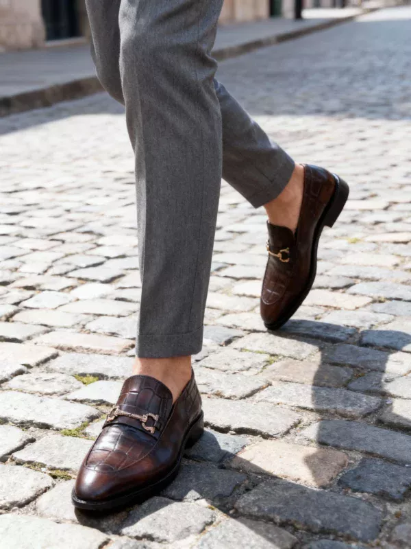 A pair of premium brown leather loafers with an antique gold horsebit and supportive medicated sole.