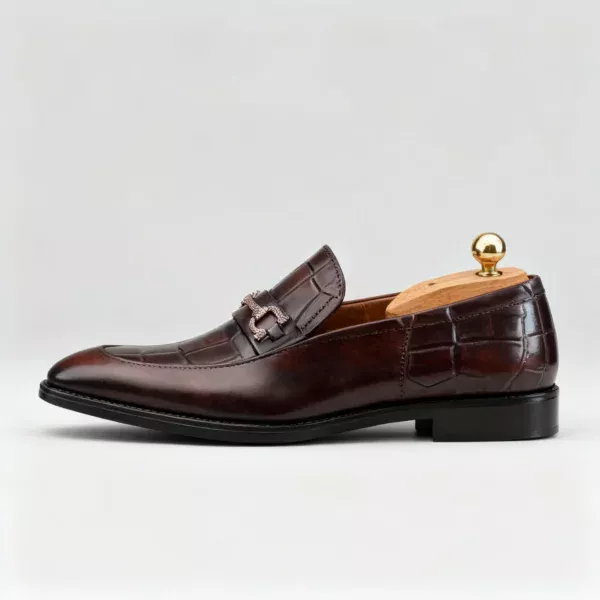 A pair of premium brown leather loafers with an antique gold horsebit and supportive medicated sole.
