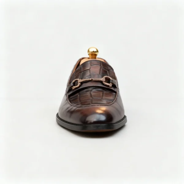 A pair of premium brown leather loafers with an antique gold horsebit and supportive medicated sole.