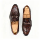 A pair of premium brown leather loafers with an antique gold horsebit and supportive medicated sole.