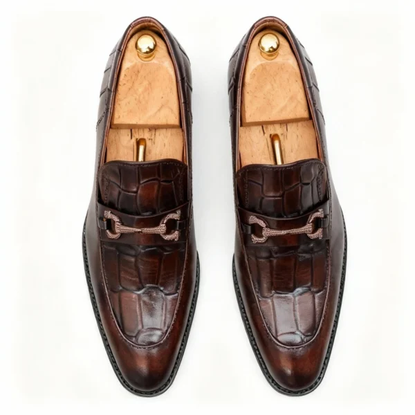 A pair of premium brown leather loafers with an antique gold horsebit and supportive medicated sole.