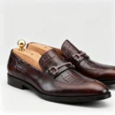 A pair of premium brown leather loafers with an antique gold horsebit and supportive medicated sole.